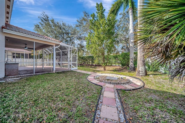 view of yard with a lanai, a ceiling fan, and a patio area