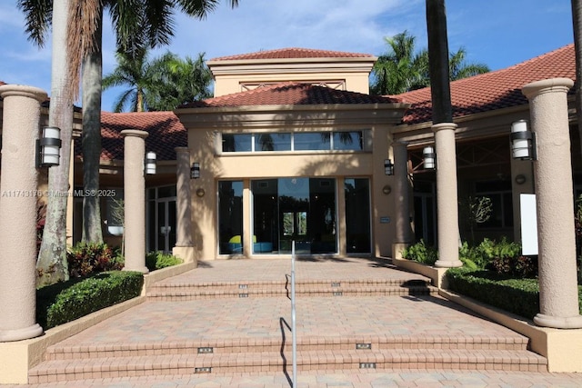 exterior space with stucco siding and a tile roof
