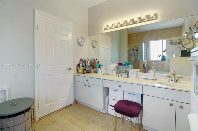 bathroom featuring a shower with door, vanity, and tile patterned floors