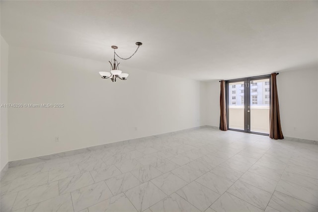 unfurnished room with french doors, baseboards, and an inviting chandelier