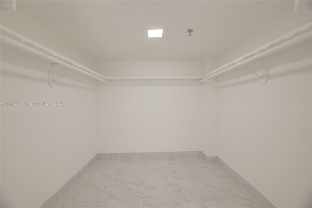 spacious closet featuring marble finish floor