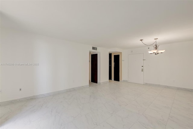 empty room with baseboards, marble finish floor, visible vents, and a notable chandelier