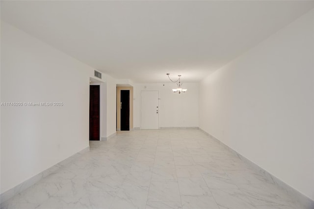 empty room featuring marble finish floor, baseboards, visible vents, and a notable chandelier