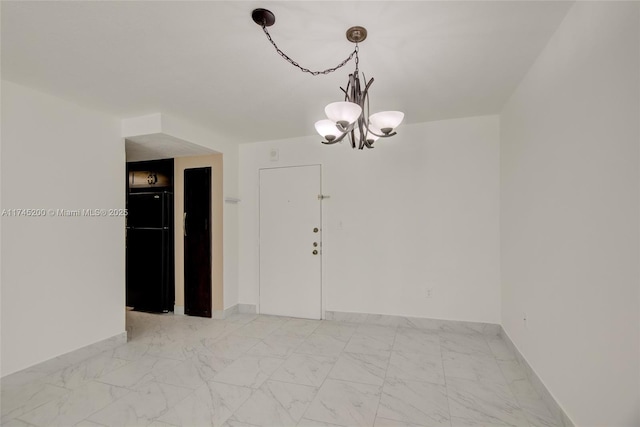 unfurnished room featuring marble finish floor, baseboards, and a chandelier