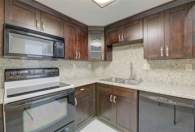 kitchen featuring black appliances, glass insert cabinets, decorative backsplash, and a sink