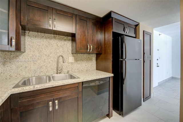 kitchen featuring dark brown cabinetry, dishwasher, freestanding refrigerator, marble finish floor, and a sink