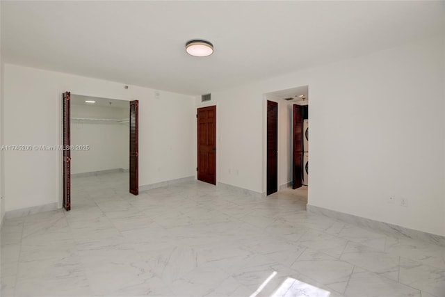 unfurnished bedroom with marble finish floor, a closet, visible vents, and baseboards