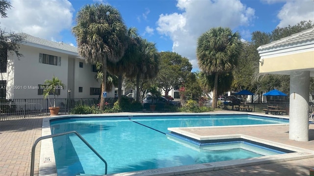 pool with a patio area and fence