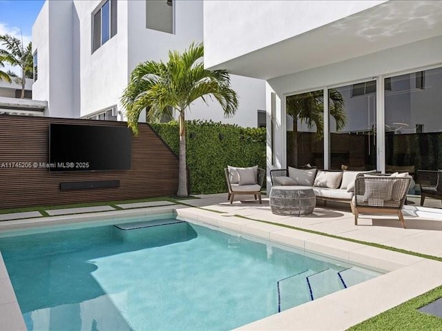 view of swimming pool with an outdoor living space with a fire pit and a patio area