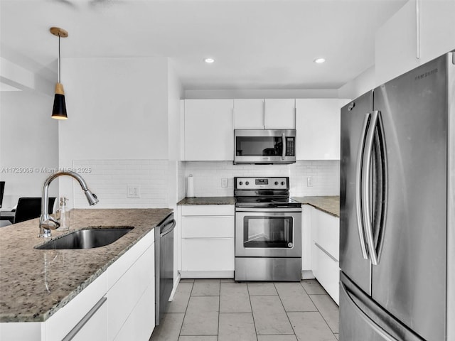 kitchen with white cabinetry, appliances with stainless steel finishes, sink, and decorative light fixtures