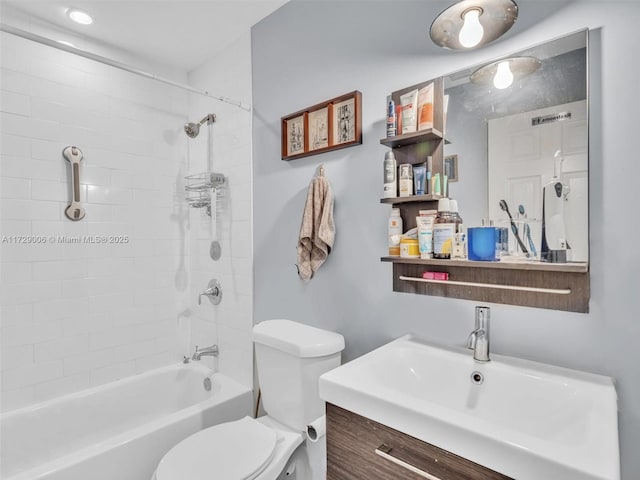 full bathroom featuring vanity, tiled shower / bath, and toilet