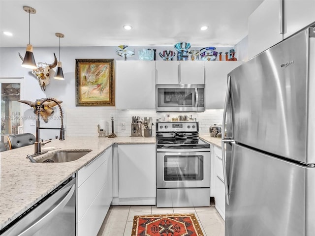 kitchen featuring white cabinetry, sink, pendant lighting, and stainless steel appliances