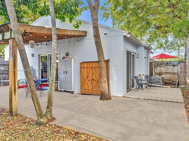 back of property with ceiling fan and a patio area