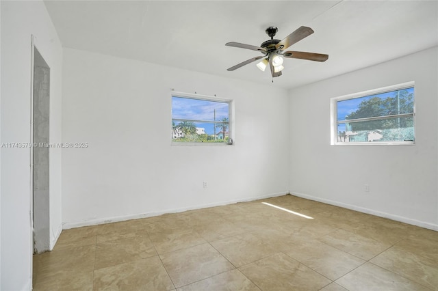 spare room featuring ceiling fan and a wealth of natural light