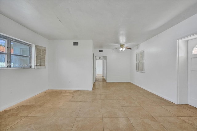 tiled empty room with a healthy amount of sunlight and ceiling fan