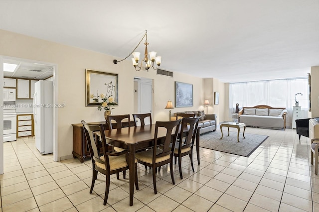 tiled dining room with a chandelier