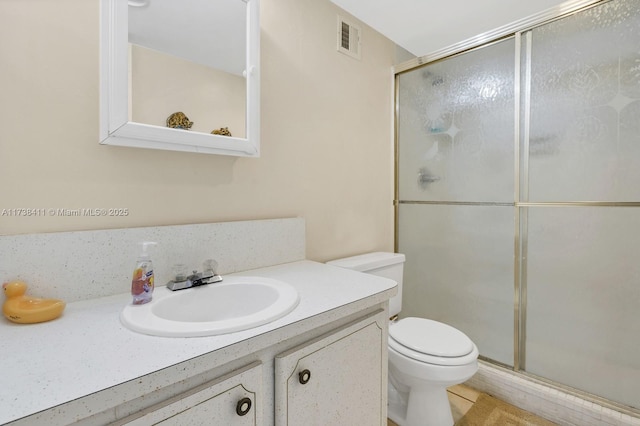 bathroom featuring vanity, toilet, and walk in shower