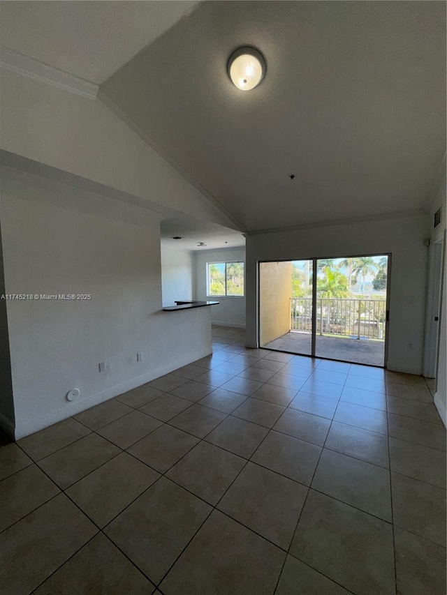 unfurnished room with lofted ceiling and tile patterned flooring