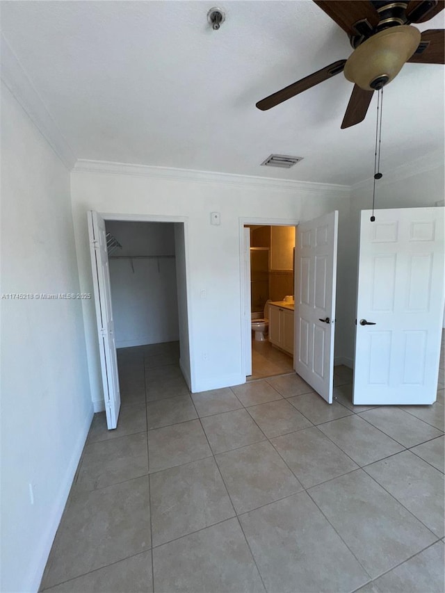 unfurnished bedroom featuring ornamental molding, a closet, and light tile patterned flooring