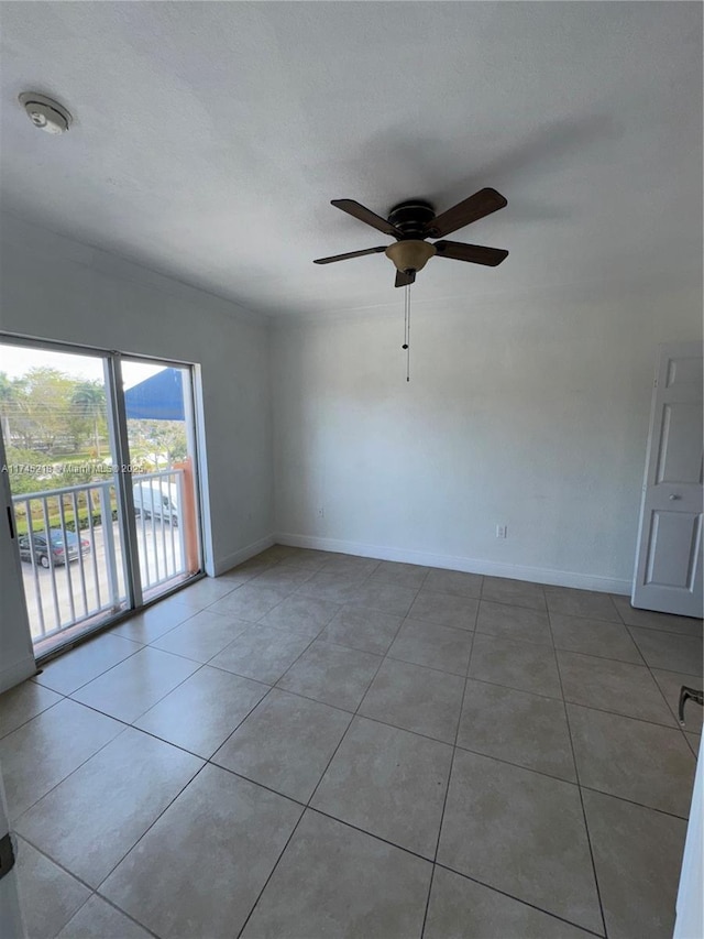 tiled spare room with ceiling fan