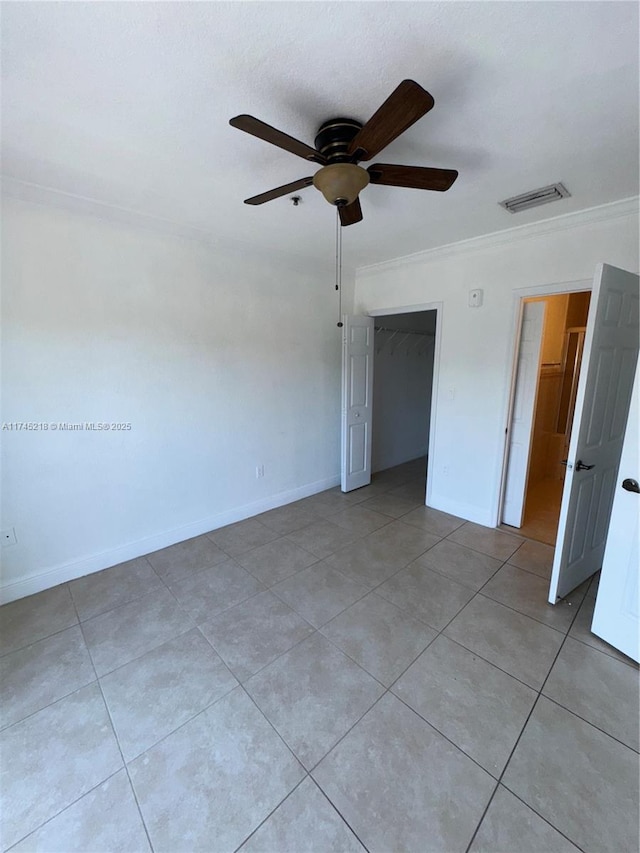 unfurnished bedroom featuring light tile patterned floors, ornamental molding, and ceiling fan