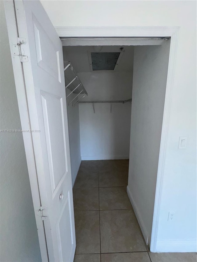 walk in closet with dark tile patterned floors