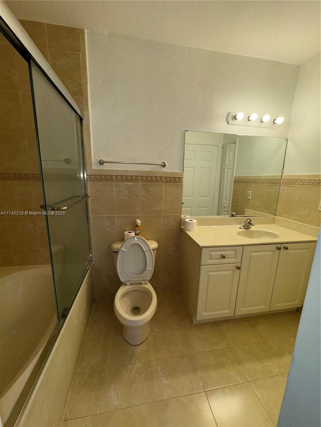 full bathroom featuring tile patterned flooring, vanity, tile walls, and toilet