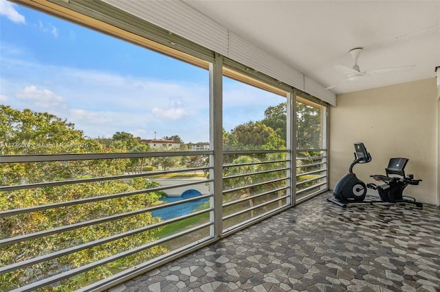 unfurnished sunroom featuring ceiling fan