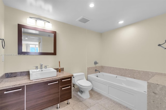 bathroom featuring vanity, tile patterned flooring, a washtub, and toilet