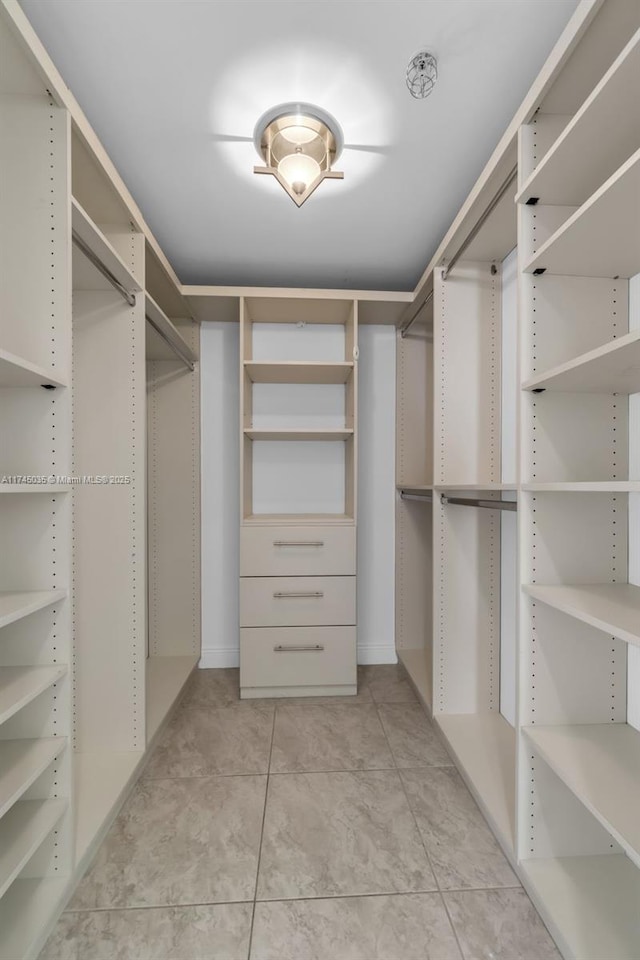 walk in closet with light tile patterned flooring