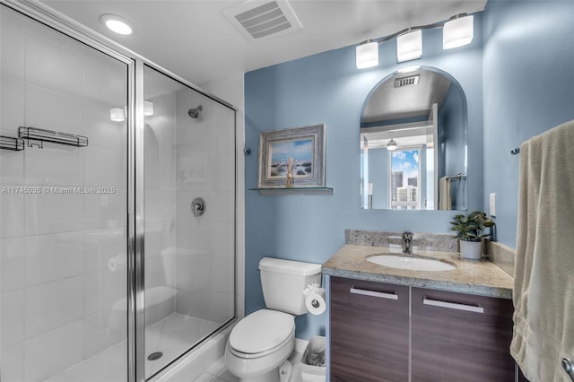 bathroom featuring an enclosed shower, vanity, and toilet