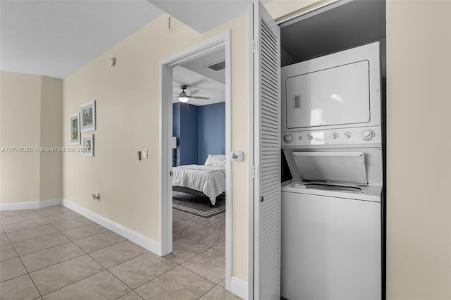 washroom featuring ceiling fan, stacked washer and clothes dryer, and light tile patterned floors