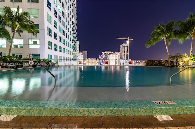 view of pool at twilight