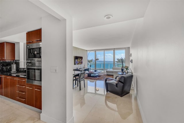 interior space with stovetop, backsplash, light tile patterned floors, and expansive windows