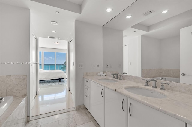 bathroom featuring vanity and tiled bath