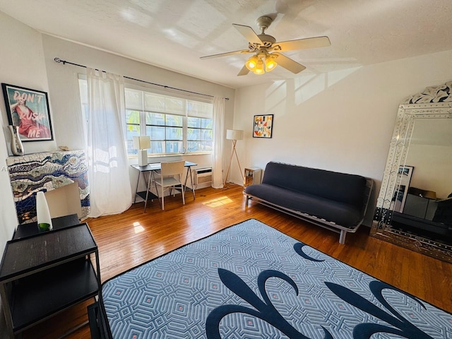 living room with wood-type flooring and ceiling fan