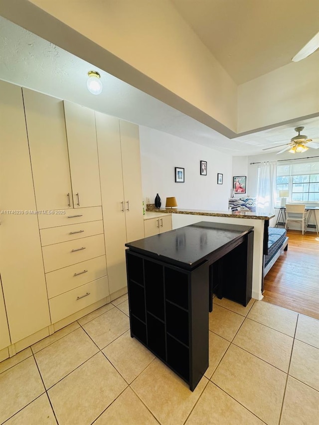 kitchen with white cabinetry, ceiling fan, light tile patterned flooring, and a kitchen island