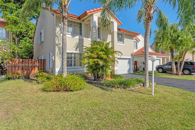 mediterranean / spanish-style home featuring a garage and a front lawn