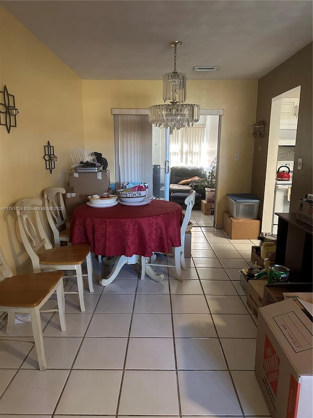 tiled dining space with a notable chandelier