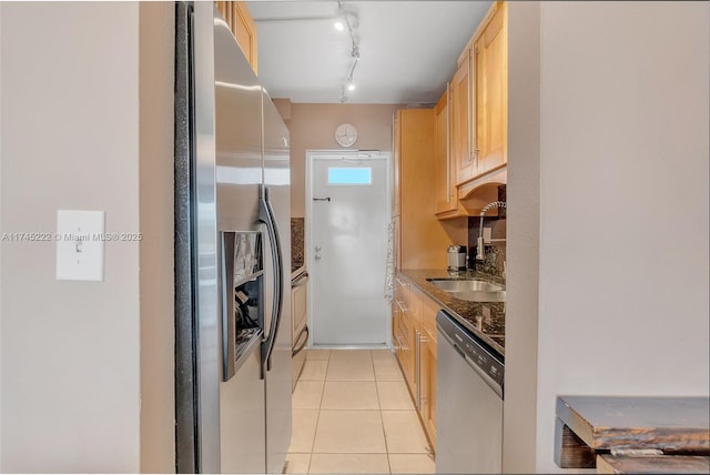 kitchen featuring sink, light brown cabinets, light tile patterned floors, appliances with stainless steel finishes, and stone counters