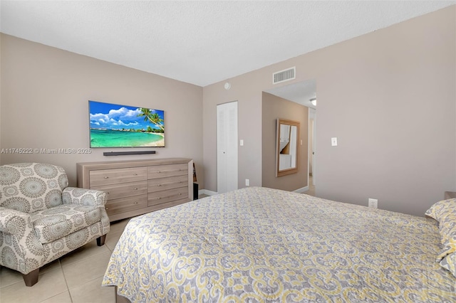 tiled bedroom with a textured ceiling