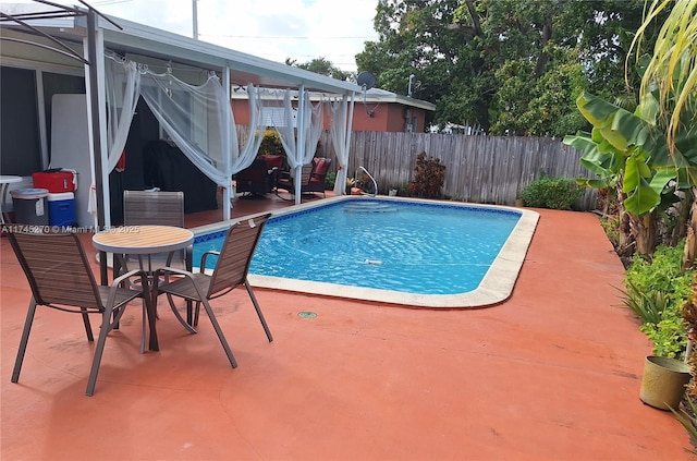 view of pool with a patio area, fence, a fenced in pool, and a lanai