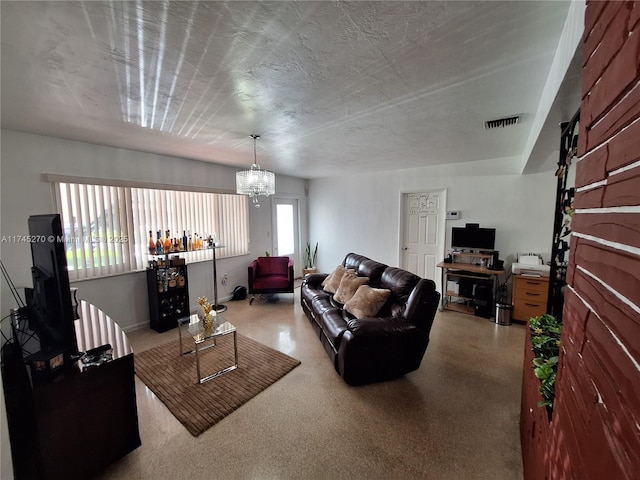 living room with visible vents, a notable chandelier, and a textured ceiling