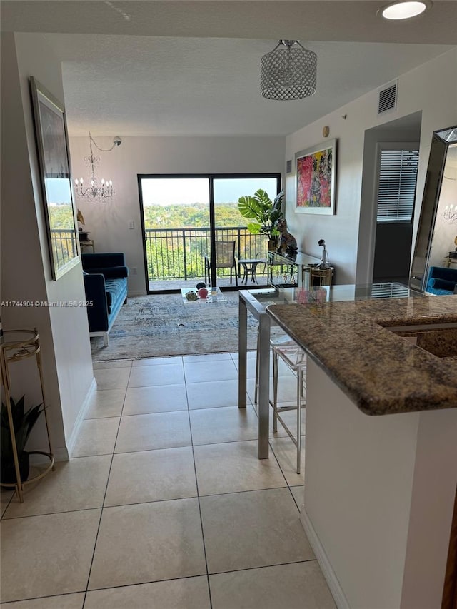 3530 SW 22nd St Unit 706, Miami, FL 33145 - kitchen featuring light tile patterned floors, baseboards, visible vents, and a breakfast bar