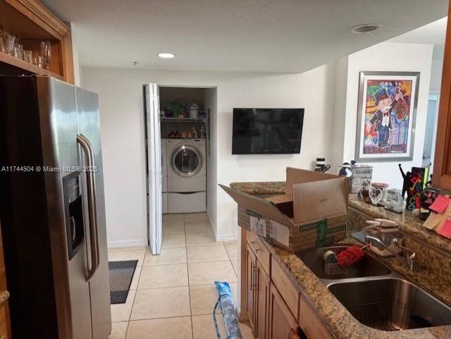 3530 SW 22nd St Unit 706, Miami, FL 33145 - kitchen with brown cabinets, stone countertops, a sink, washer / dryer, and stainless steel fridge