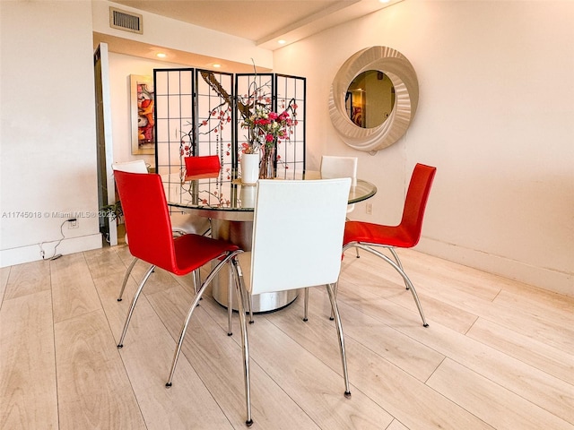 dining space with visible vents, baseboards, and wood finished floors