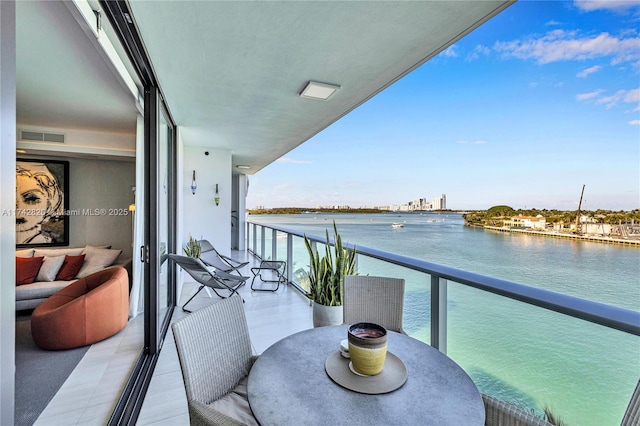 balcony featuring a water view and visible vents