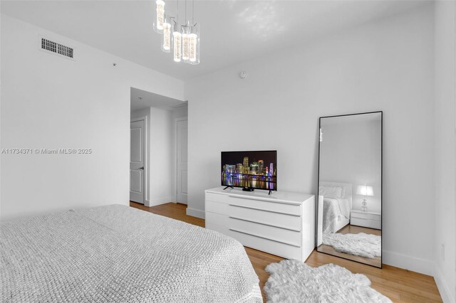 315 NE 3rd Ave Unit 1804, Fort Lauderdale, FL 33301 - bedroom with baseboards, visible vents, a notable chandelier, and wood finished floors