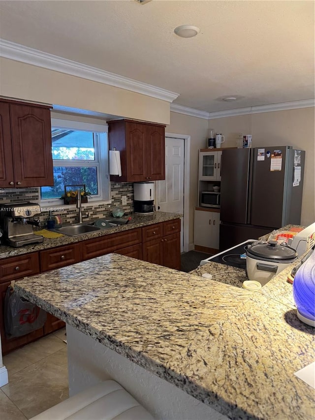 2770 NW 164th Ter, Miami Gardens, FL 33054 - kitchen featuring freestanding refrigerator, a sink, crown molding, stainless steel microwave, and backsplash