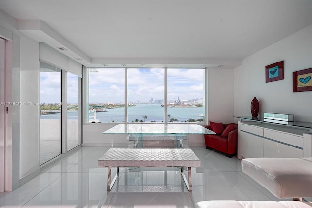 interior space with a wealth of natural light, light tile patterned flooring, and a water view